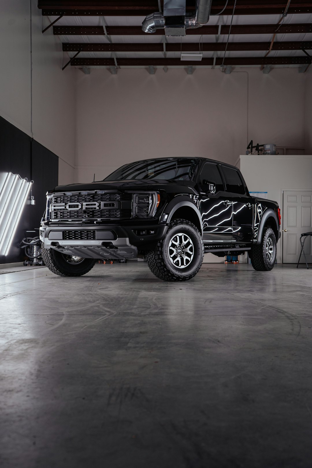 a-black-truck-parked-inside-of-a-garage-sz4v3mu5qqs
